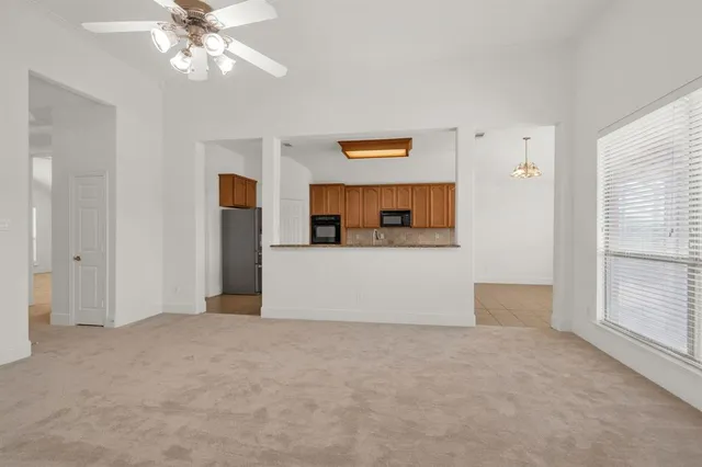 a view of a room with a ceiling fan and window