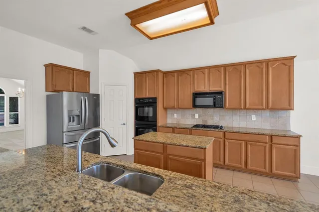 a kitchen with stainless steel appliances granite countertop a sink stove and refrigerator