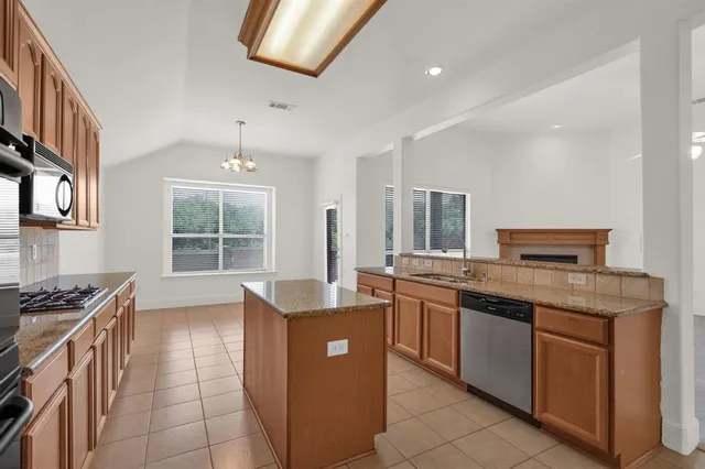 a kitchen with stainless steel appliances a sink stove and cabinets