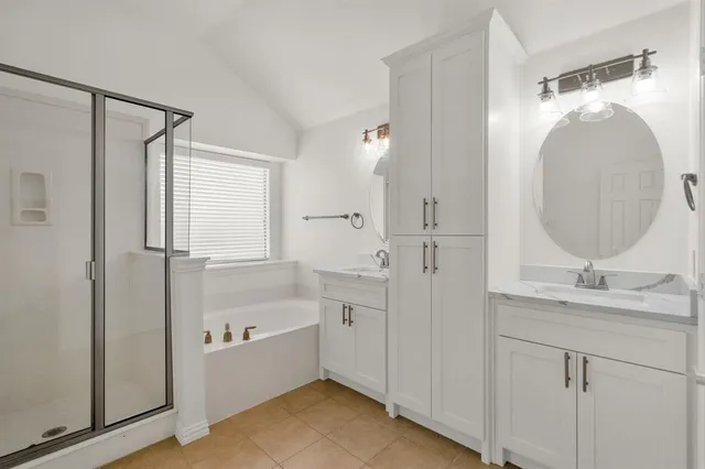 a bathroom with a granite countertop sink mirror and a bathtub