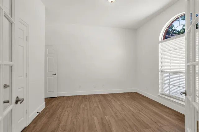 a view of a room with wooden floor and a window