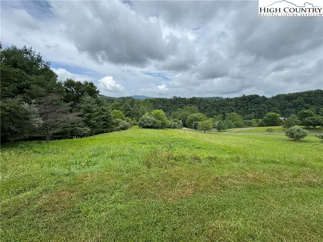 a view of a green field with wooden fence