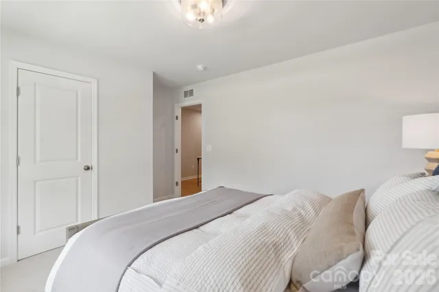 a bedroom with a bed and a lamp