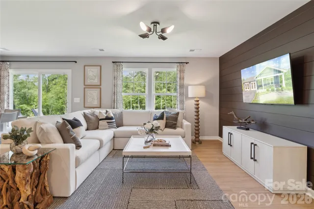a living room with furniture a large window and a flat screen tv