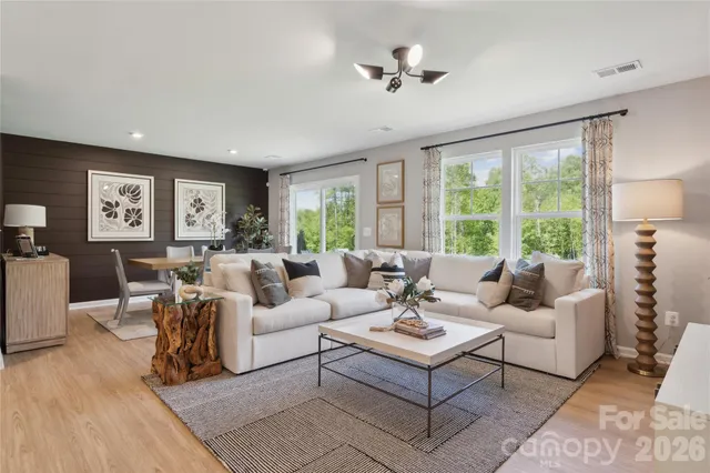 a living room with furniture potted plant and a large window