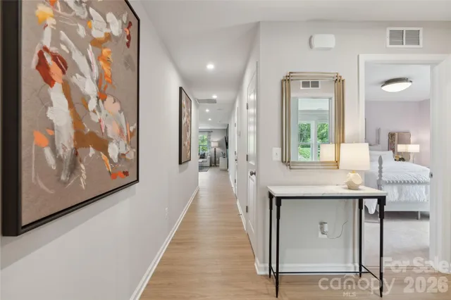 a view of a hallway with furniture and wooden floor
