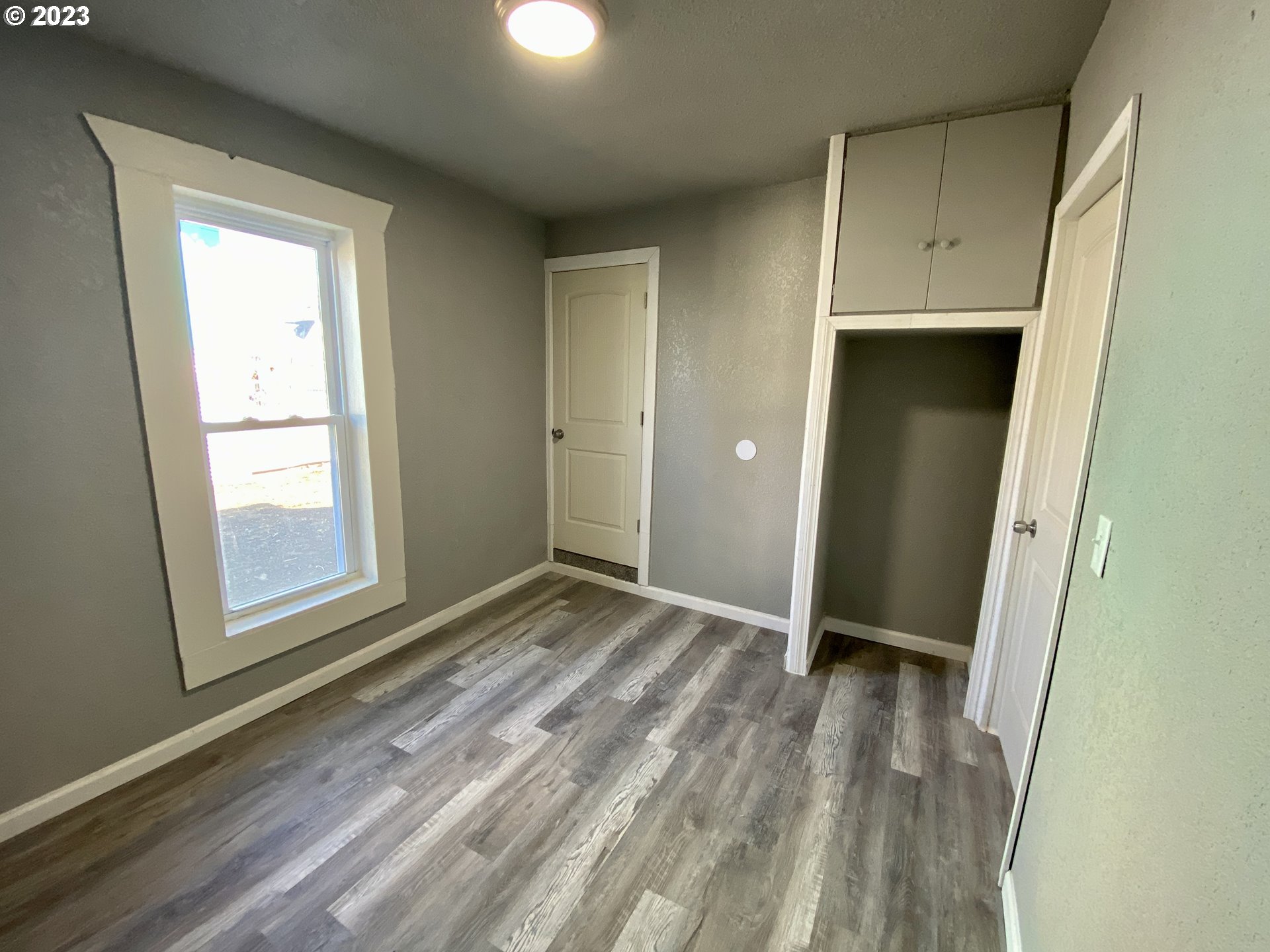 417 East Court Street Goldendale, WA 98620 - Photo 11 of 19 a view of an empty room with wooden floor and a window