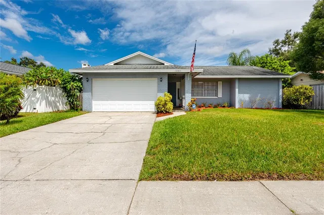 a front view of a house with a garden and trees