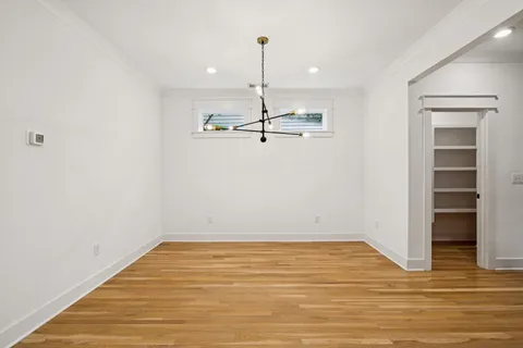 a room with wooden floor and ceiling fan