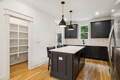 a kitchen with a counter top a stove and wooden floor