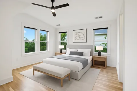 a bedroom with a bed wooden floor and window