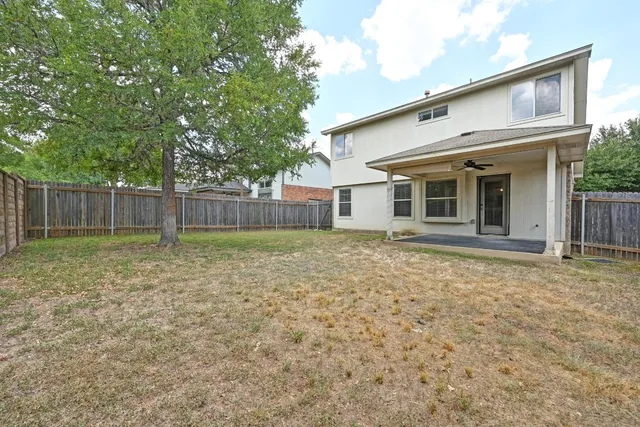 a view of a yard with wooden fence