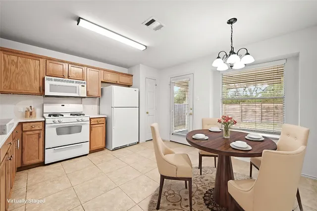 a kitchen with a white table chairs stove and refrigerator