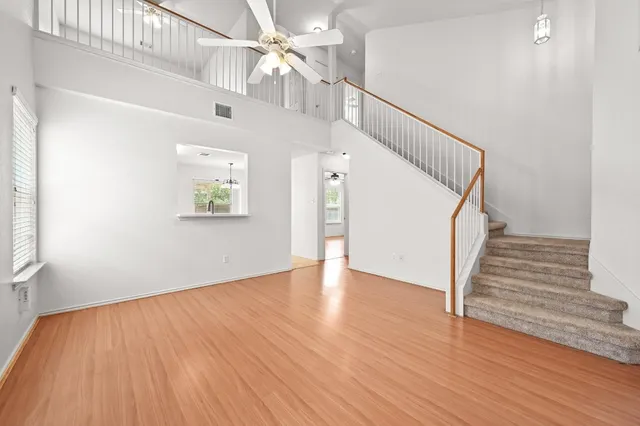 wooden floor in an empty room with a chandelier fan