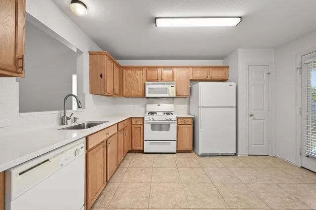 a kitchen with white cabinets and white appliances