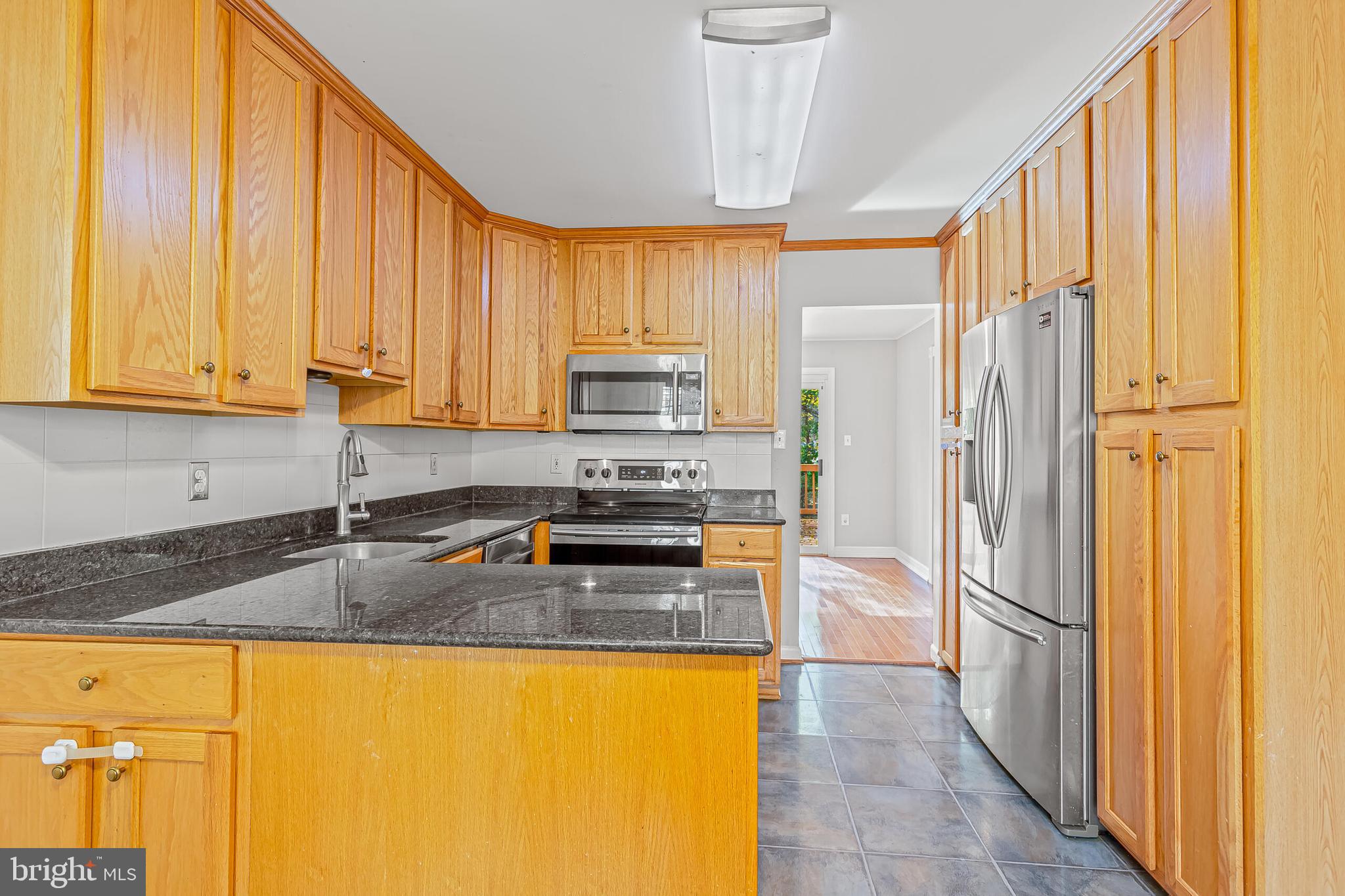 12027 Cheviot Drive Herndon, VA 20170 - Photo 4 of 29 a kitchen with granite countertop a refrigerator and a sink