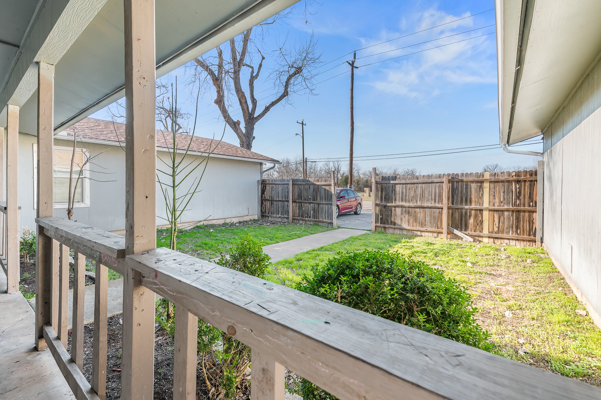 410 Old Thorndale Road, Unit D Taylor, TX 76574 - Photo 5 of 14 Covered porch with wood railing overlooking a fenced yard