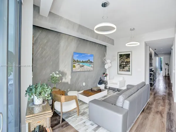 a living room with stainless steel appliances kitchen island granite countertop furniture and a wooden floor