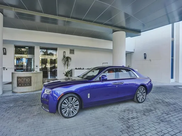 a kitchen with stainless steel appliances kitchen island granite countertop a table chairs and a refrigerator