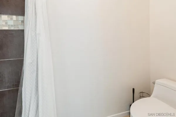 a white toilet sitting next to a white wall