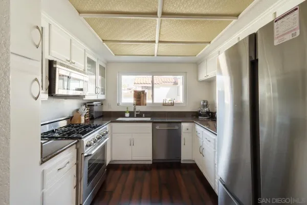 a kitchen with stainless steel appliances a sink stove and cabinets