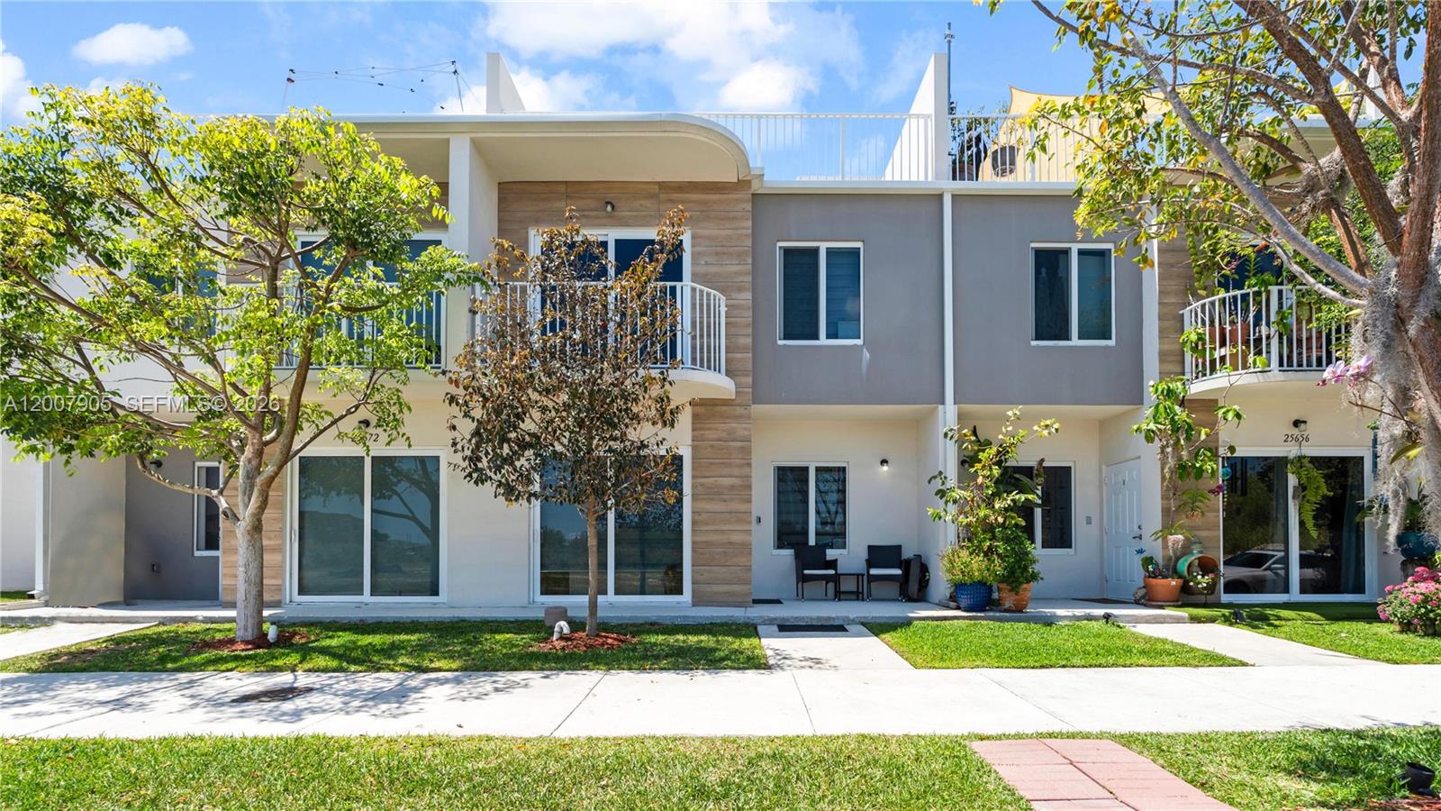 25664 Southwest 143rd Path, Unit 25664 Homestead, FL 33032 - Photo 1 of 17 a front view of a house with a yard and garage