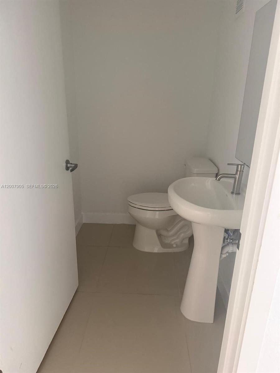 25664 Southwest 143rd Path, Unit 25664 Homestead, FL 33032 - Photo 11 of 17 a white toilet sitting next to a white sink
