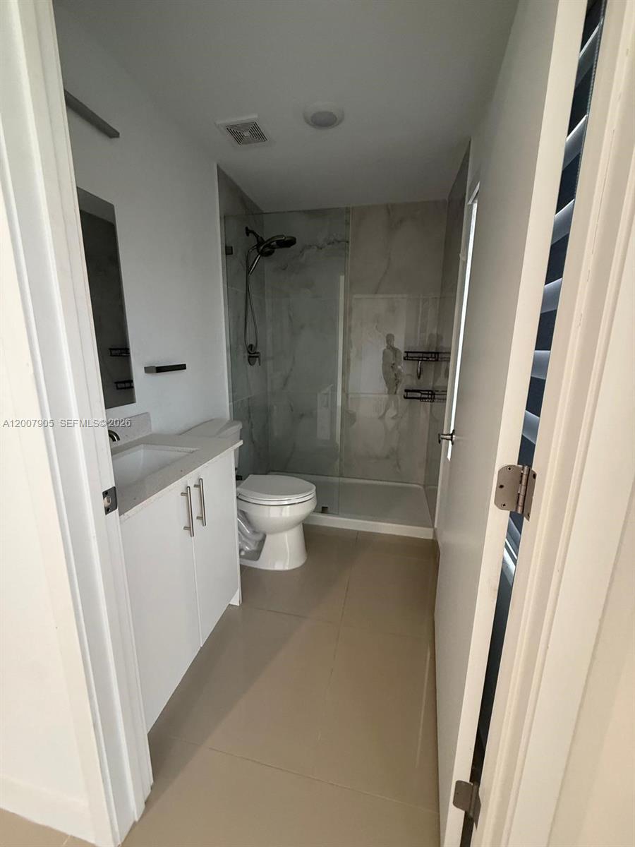 25664 Southwest 143rd Path, Unit 25664 Homestead, FL 33032 - Photo 5 of 17 a bathroom with a sink a toilet and shower