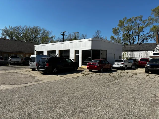 a front view of a house with cars parked