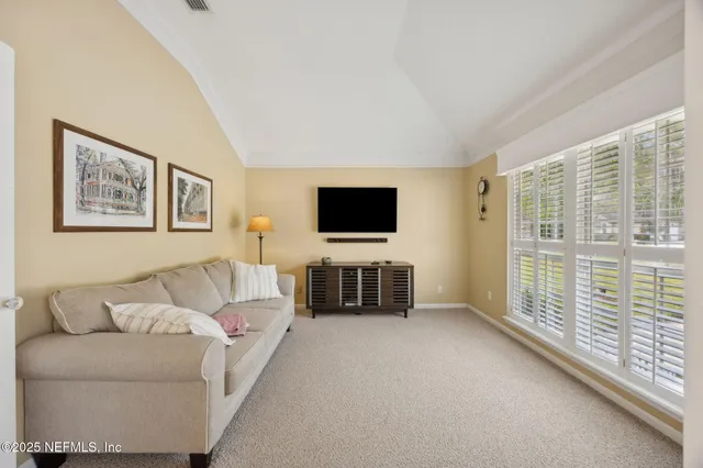a view of a dining room with furniture a chandelier and wooden floor