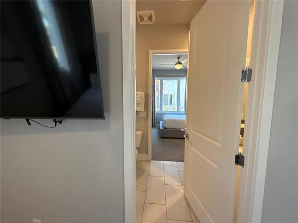 a bedroom with a bed and a flat tv screen on the dresser