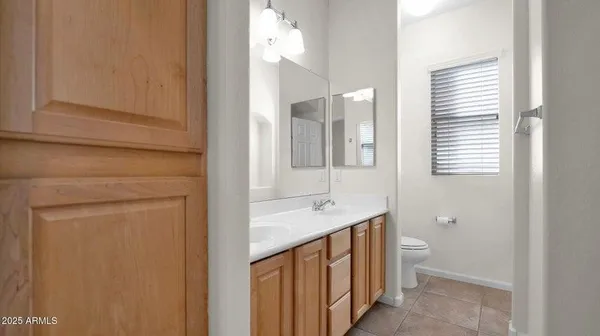 a bathroom with a granite countertop sink a toilet and a mirror