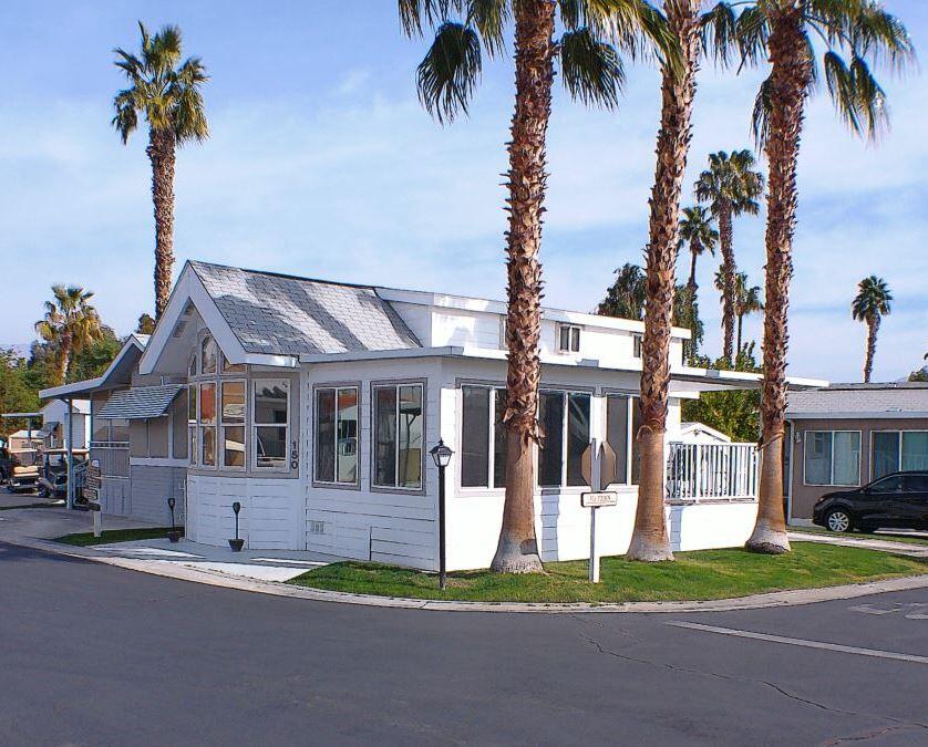 a view of a house with a yard and palm trees