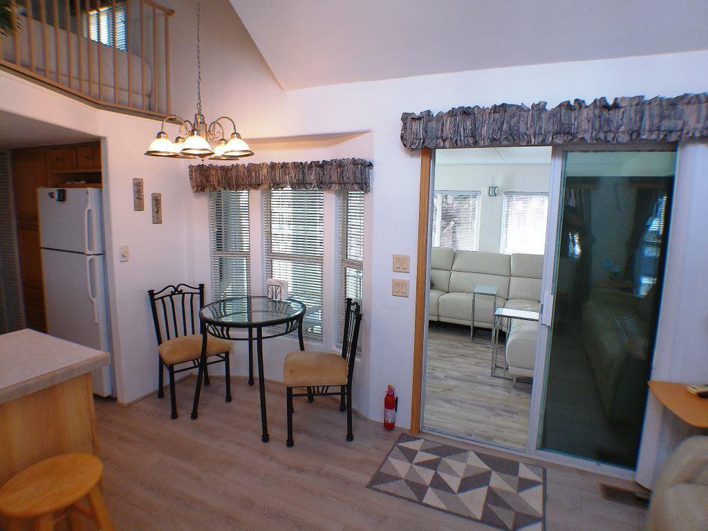 84136 Ave 44, Unit 150 Indio, CA 92203 - Photo 17 of 37 a view of a dining room with furniture window and wooden floor