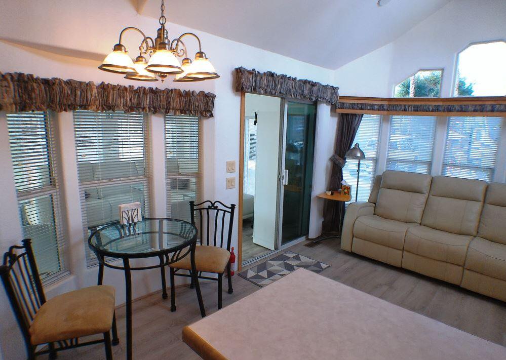 84136 Ave 44, Unit 150 Indio, CA 92203 - Photo 21 of 37 a living room with furniture a chandelier and a dining table