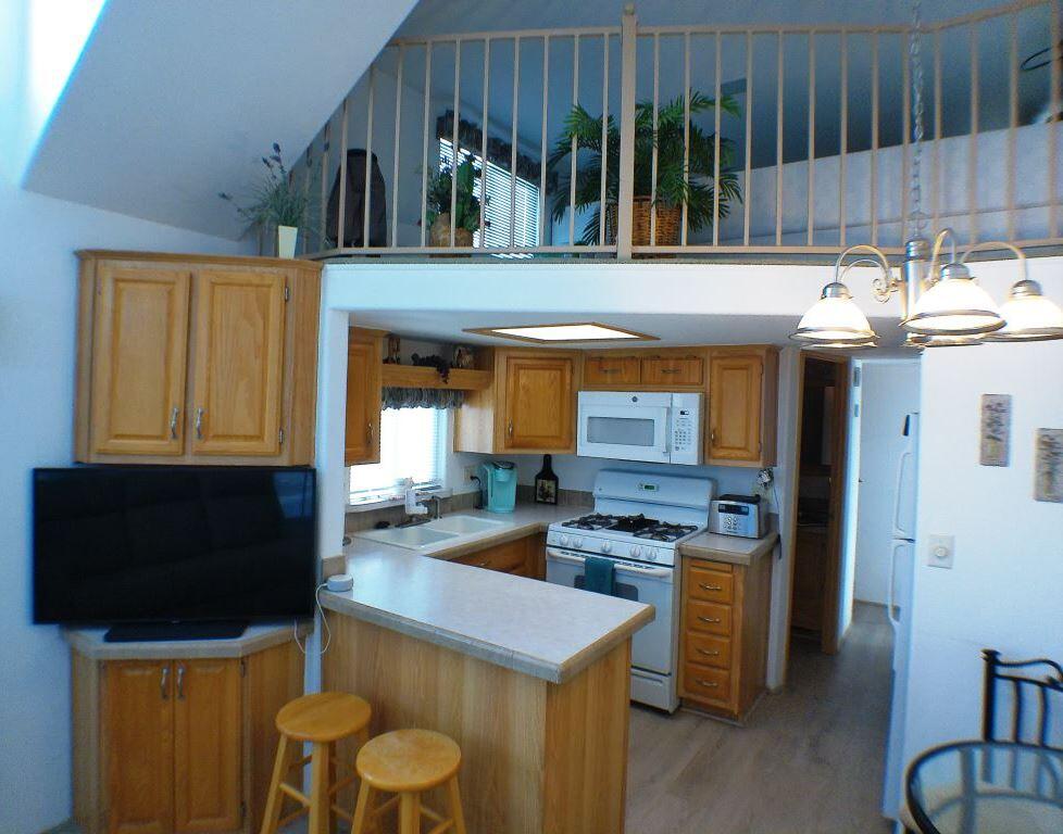 84136 Ave 44, Unit 150 Indio, CA 92203 - Photo 23 of 37 a kitchen with a sink a stove and chairs