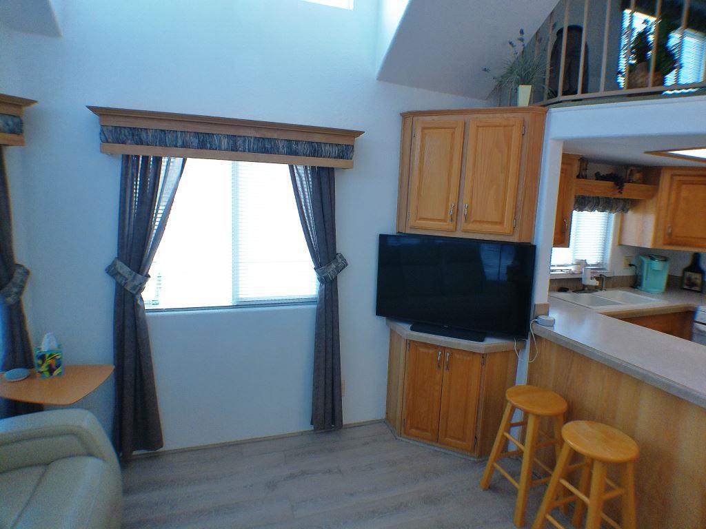 84136 Ave 44, Unit 150 Indio, CA 92203 - Photo 27 of 37 a living room with furniture and a flat screen tv