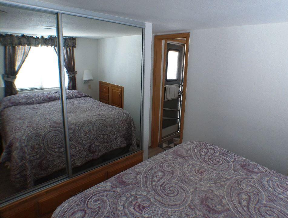 84136 Ave 44, Unit 150 Indio, CA 92203 - Photo 32 of 37 a bedroom with a bed and a mirror