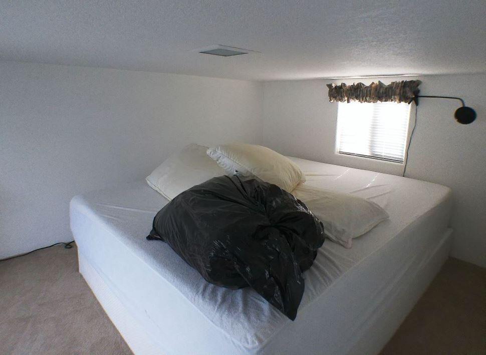 84136 Ave 44, Unit 150 Indio, CA 92203 - Photo 36 of 37 a bed sitting in a bedroom next to a window and a chandelier