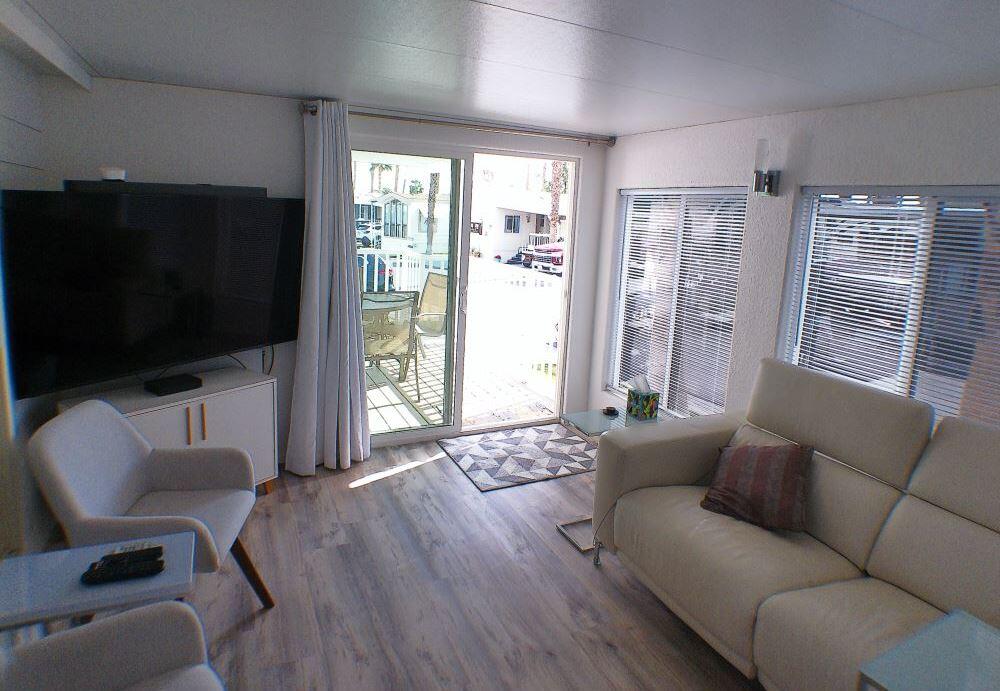 84136 Ave 44, Unit 150 Indio, CA 92203 - Photo 9 of 37 a living room with furniture a flat screen tv and a large window