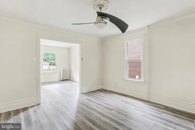 an empty room with windows and cabinet