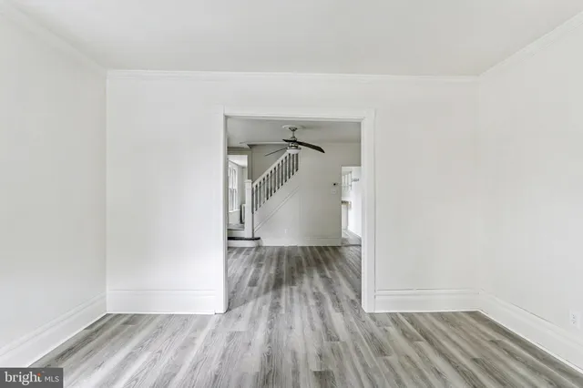 a view of empty room with wooden floor and bench