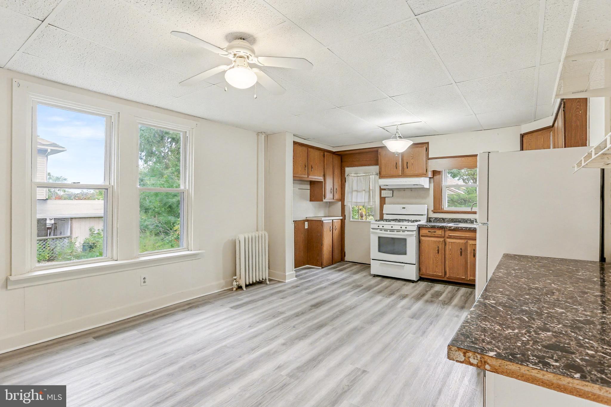 233 West Columbia Road Enola, PA 17025 - Photo 4 of 15 a kitchen with stainless steel appliances granite countertop a refrigerator a sink dishwasher a stove and white countertops with wooden floor