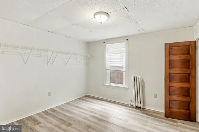 an empty room with cabinet and windows
