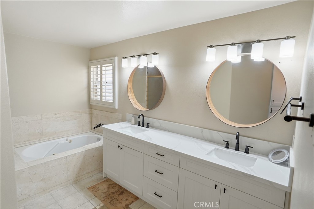 25550 Longfellow Place Stevenson Ranch, CA 91381 - Photo 19 of 30 a bathroom with a double vanity sink double mirror and bathtub