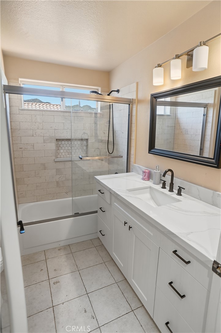 25550 Longfellow Place Stevenson Ranch, CA 91381 - Photo 23 of 30 a bathroom with a granite countertop sink mirror and shower