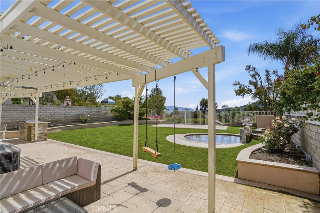 25550 Longfellow Place Stevenson Ranch, CA 91381 - Photo 24 of 30 a view of a patio with a table and chairs under an umbrella