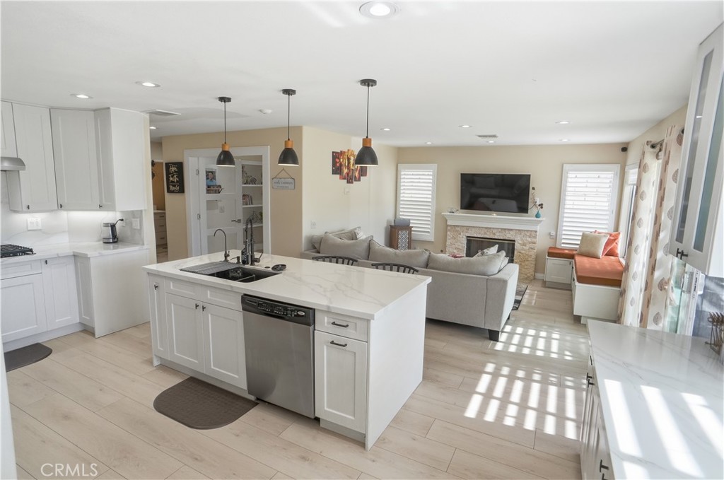 25550 Longfellow Place Stevenson Ranch, CA 91381 - Photo 8 of 30 a kitchen with stainless steel appliances granite countertop a stove a sink dishwasher a refrigerator and white cabinets with wooden floor