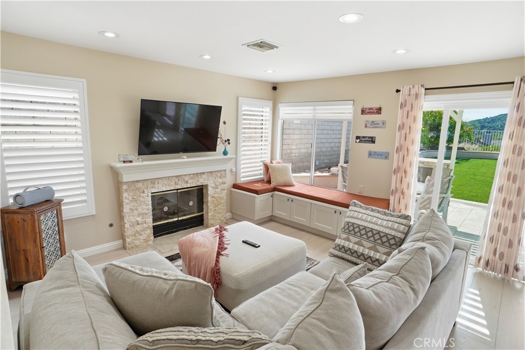25550 Longfellow Place Stevenson Ranch, CA 91381 - Photo 10 of 30 a living room with furniture a flat screen tv and a fireplace