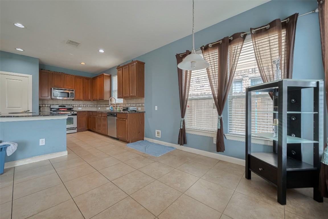 1703 Macclesby Lane Houston, TX 77049 - Photo 11 of 41 a kitchen with stainless steel appliances granite countertop a refrigerator and a stove top oven